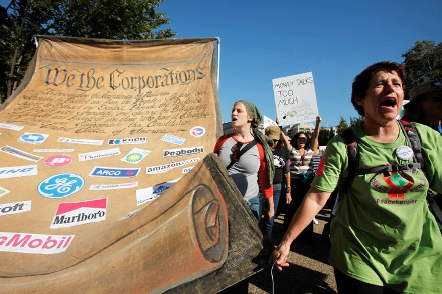 Linda Wiener, right, of Vancouver, Wash., helps carry a large "We the Corporations" canvas through Pennsylvania Avenue, part of Occupy DC activities in Washington, on Thursday, Oct. 6, 2011. (AP Photo/Jacquelyn Martin)