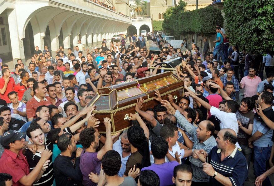 Mourners carry the coffin of victims of clashes between protesters and security forces in Cairo on Monday. (Associated Press)
