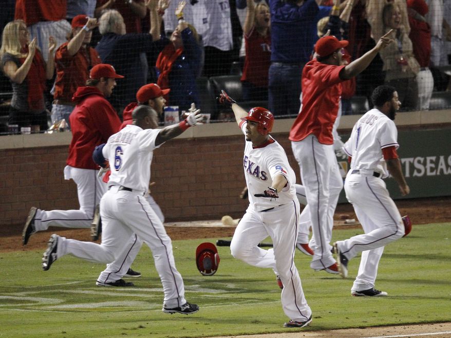 Texas Rangers&#x27; Nelson Cruz, center, and teammates celebrate after he hit a grand slam home run in the 11th inning of Game 2 of baseball&#x27;s American League championship series to beat the Detroit Tigers 7-3, Monday, Oct. 10, 2011, in Arlington, Texas.(AP Photo/Eric Gay)