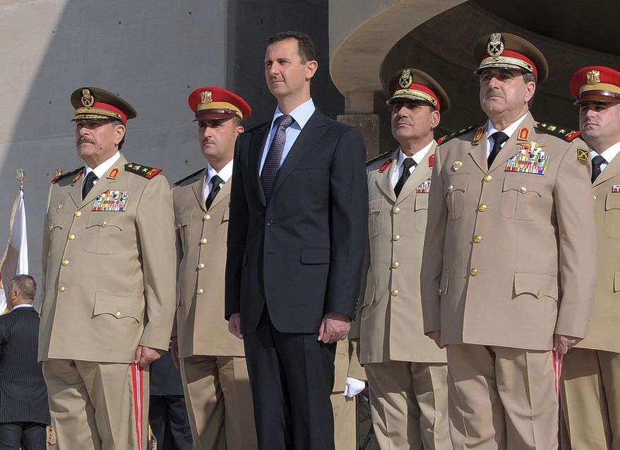 In this photo released by the Syrian official news agency SANA, Syrian President Bashar Assad, center, stands next to Syrian Defense Minister Gen. Dawoud Rajha, right, and Chief of Staff Gen. Fahed al-Jasem el-Freij, left, during a ceremony to mark the 38th anniversary of the October 1973 Arab-Israeli war, in Damascus, Syria, on Thursday Oct. 6, 2011. Syrian troops stormed villages close to the border with Turkey on Thursday, hunting armed military defectors who fought back in clashes that left at least four soldiers and three others dead, activists said. (AP Photo/SANA)