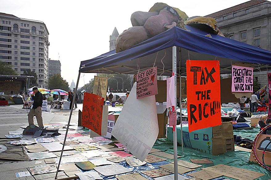 People start to move about Freedom Plaza in Washington, Monday, Oct. 10, 2011, among protest signs, as part of a protest against the war and corporate America. (AP Photo/Jacquelyn Martin)