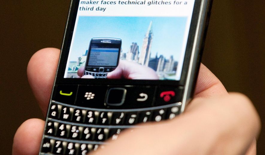 A subscriber holds a BlackBerry in Ottawa. (Associated Press)