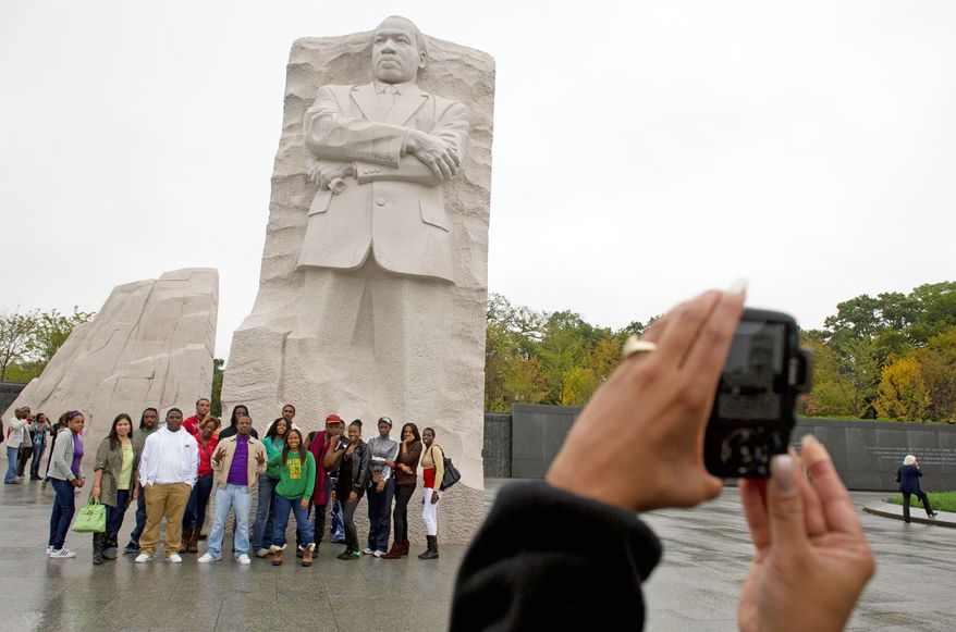 Dawn Covington takes a group photo of students from the Career Academy in Baltimore on Thursday as they gather around the Martin Luther King, Jr. National Memorial on the Mall. Hurricane Irene in August forced postponement of its dedication, which will take place on Sunday. (Rod Lamkey Jr./The Washington Times)