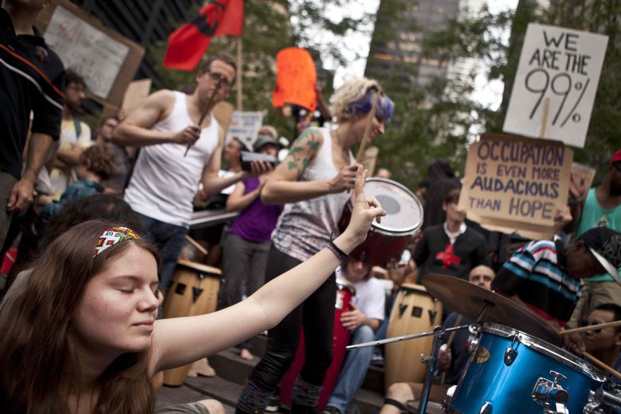 ** FILE ** A protester affiliated with the Occupy Wall Street demonstration listens to a drum circle in Zuccotti Park in New York on Monday, Oct. 10, 2011. (AP Photo/Andrew Burton)