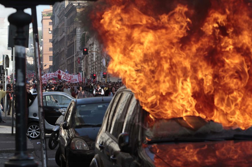 A car is set on fire as protesters clash with police in Rome, Saturday, Oct. 15, 2011, as violence broke out during a demonstration, part of worldwide protests against corporate greed and austerity measures. The "Occupy Wall Street" protests, that began in Canada and spread to cities across the U.S., moved Saturday to Asia and Europe, linking up with anti-austerity demonstrations that have raged across the debt-ridden continent for months. (AP Photo/Gregorio Borgia)