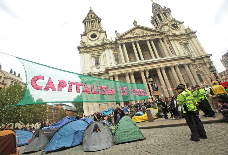 Police look on as protesters, who are part of the Occupy London Stock Exchange demonstration, continue their demonstration outside St Paul's Cathedral in London on Sunday. There were also protests in Rome and Amsterdam. (Associated Press)