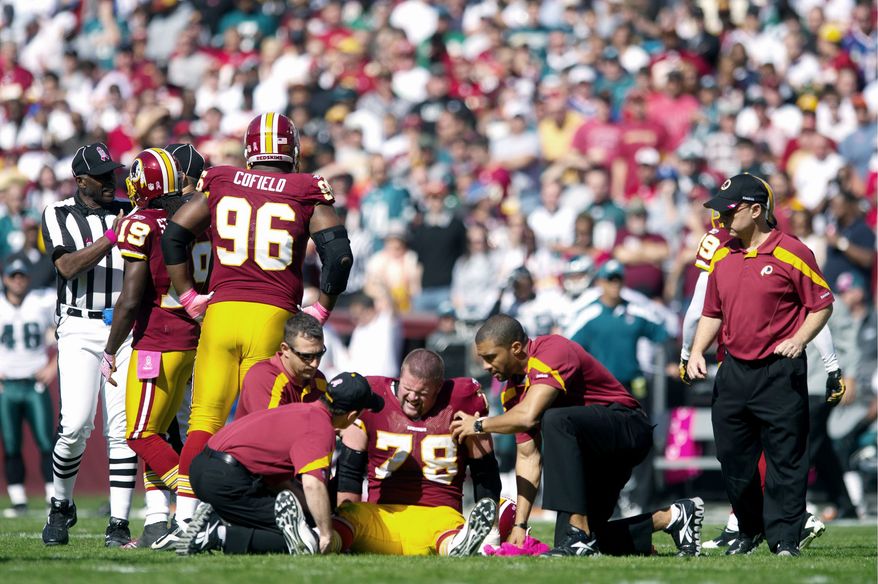 Redskins offensive lineman Kory Lichtensteiger is tended to after suffering a knee injury during the first quarter against Philadelphia. He reportedly tore his ACL and MCL. (Andrew Harnik/The Washington Times)