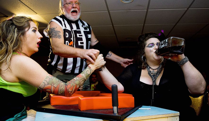 Referee Philip Yunger reacts as &quot;Scarlett O&#39;Scara,&quot; aka Ann Marie Wilson (left) of Silver Spring, and &quot;Amy Smackhouse,&quot; aka Andrea Kavanagh of the District, prepare to arm-wrestle during the D.C. Lady Arm Wrestlers league event. The arm-wrestling competitions raise money for charity. (Barbara L. Salisbury/The Washington Times)