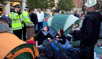 Police officers chat with protesters in a tent city in London on Monday. (Associated Press)