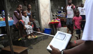 Liberians listen to the announcement of election results on a portable radio in the 19th Street area of Sinkor, Monrovia, Liberia, on Friday, Oct. 14, 2011. (AP Photo/Rebecca Blackwell)