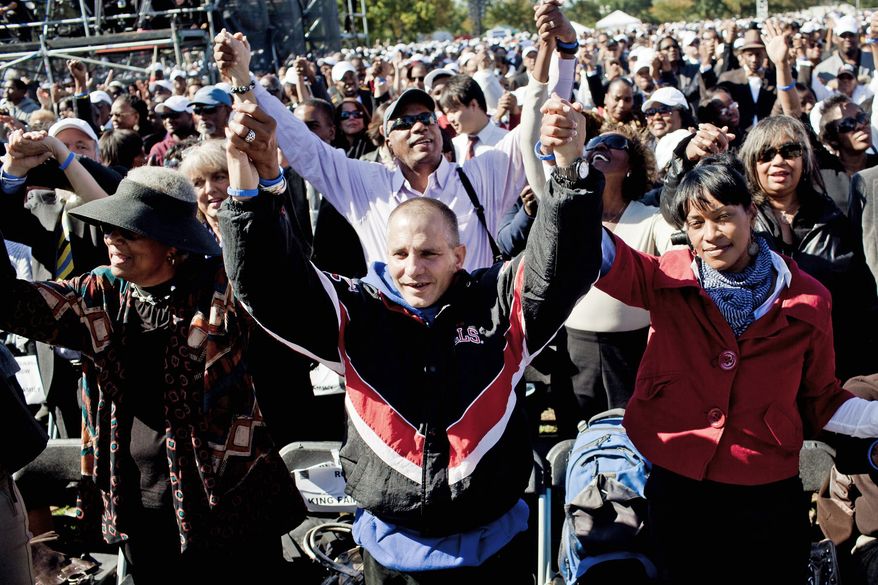 Christopher Vichiola, of Torrington, Conn., and Stephanee Gaskins (right) of North Bethesda join hands as "We Shall Overcome" was sung during the ceremonies. (T.J. Kirkpatrick/The Washington Times)