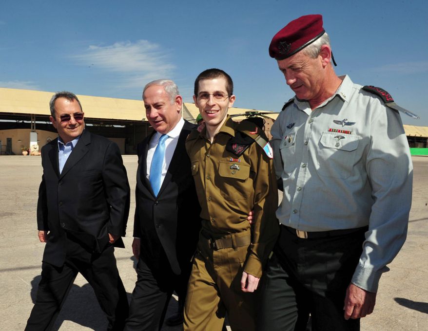 Released Israeli soldier Gilad Schalit (second from right) walks with Israeli Prime Minister Benjamin Netanyahu (second from left), Defense Minister Ehud Barak (left) and Israeli Chief of Staff Lt. Gen. Benny Gantz at the Tel Nof Air Base in southern Israel on Tuesday, Oct. 18, 2011. (AP Photo/Israeli Defense Ministry)