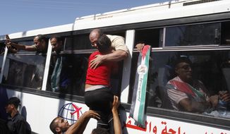 A child hugs a released Palestinian prisoner at the Rafah border crossing between Egypt and the Gaza Strip on Tuesday, Oct. 18, 2011. (AP Photo/Hatem Moussa)