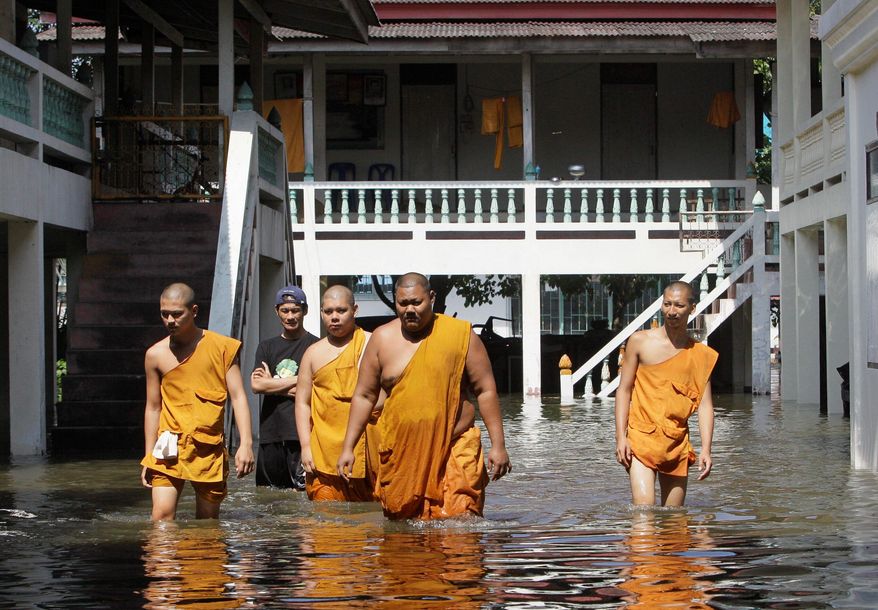 Thai Buddhist monks wade through Ban Kadee temple in Pathum Thani province, north of Bangkok, on Wednesday. Thai authorities were staging a fighting retreat Wednesday against floodwaters that threaten Bangkok after the country's oldest factory park was completely inundated and another one faced imminent threat.