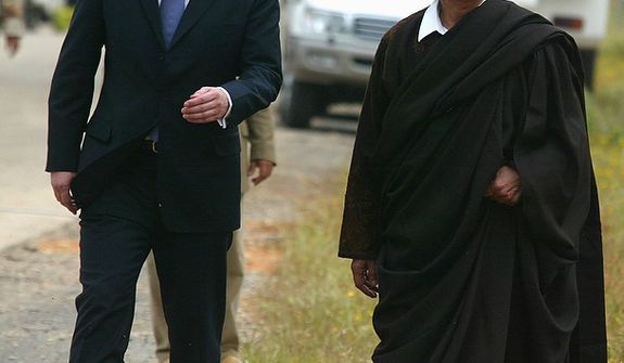 In this photo from March 25, 2004, Moammar Gadhafi (right) walks with Britain Prime Minister Tony Blair outside Tripoli, Libya. (Associated Press)