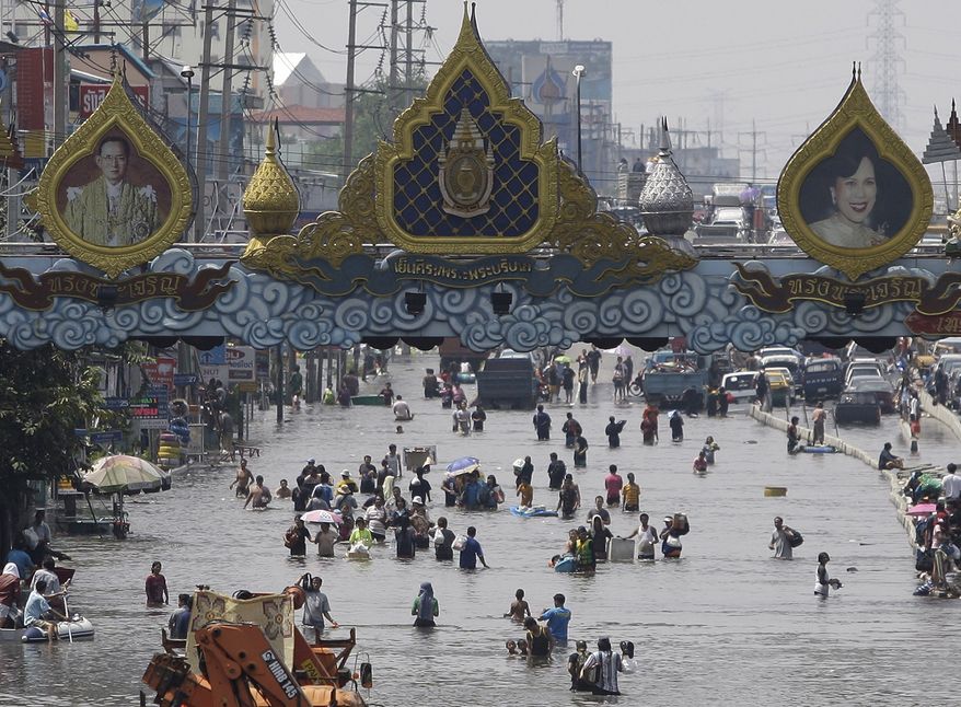 Residents wade through floods in Rangsit district on the outskirts of Bangkok on Oct. 21, 2011. (Associated Press)