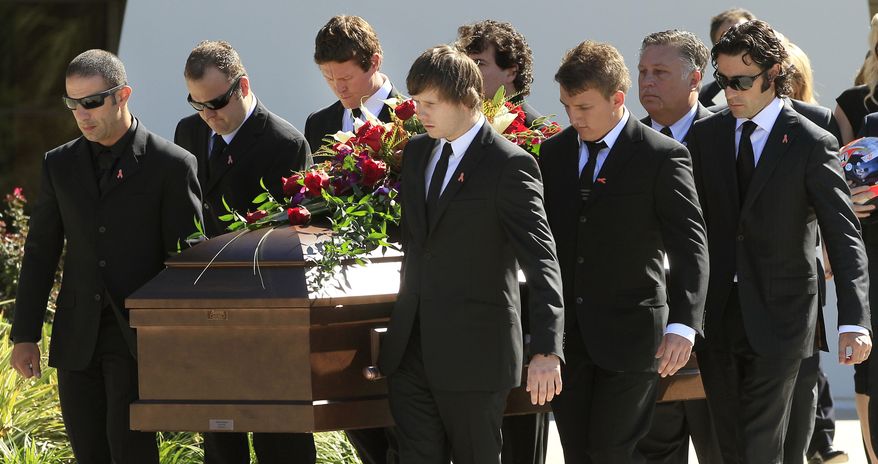 IndyCar drivers Tony Kanaan, left, of Brazil, Scott Dixon, of New Zealand, third from left, and Dario Franchitti, of Scotland, right, carry the coffin of fellow driver Dan Wheldon after funeral services Saturday, Oct 22, 2011, in St. Petersburg, Fla. Wheldon was killed Sunday, Oct. 16, 2011, in a fiery 15-car crash at the Las Vegas Motor Speedway. (AP Photo/Chris O'Meara)