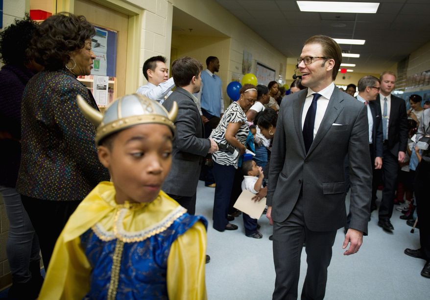 Miner Elementary School fifth-grader Keith Herbert, 10, (above) leads the way for Prince Daniel of Sweden during his visit Wednesday, complete with Swedish flags, for Nordic Food Day. London Gray, 5, tries some of the lunch specialties that included salmon with dill sauce and vinegar-soaked cucumbers. (Rod Lamkey Jr./The Washington Times)