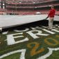 A worker removes a tarp from the infield at Busch Stadium in St. Louis on Wednesday, Oct. 26, 2011, after officials announced that Game 6 of the World Series had been postponed because of rain. (AP Photo/Jeff Roberson)