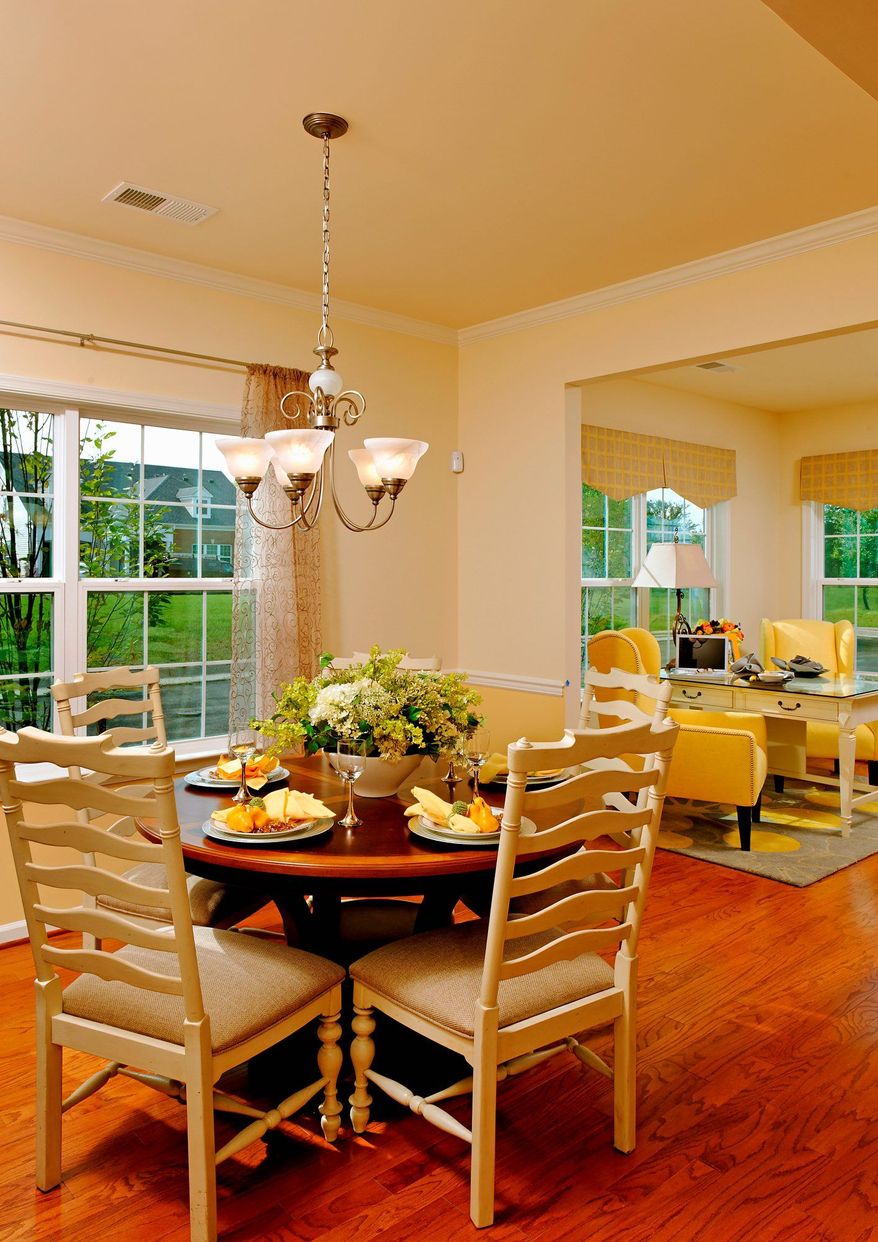 The Saxony's dining room opens into the living room, which has a corner fireplace. Also on the main level is a master-bedroom suite.