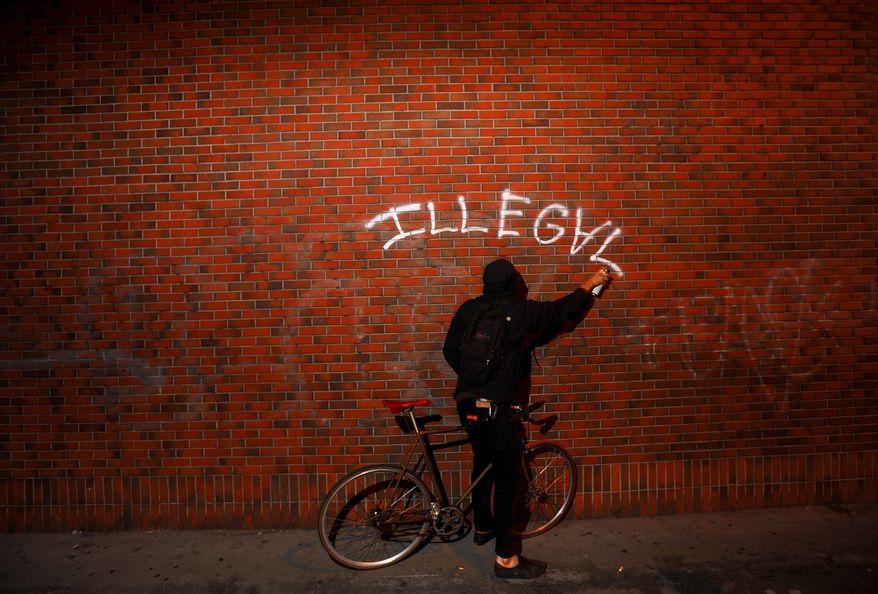 An Occupy Oakland protester spray paints the side of a building during a march on Wednesday, Oct. 26, 2011, in Oakland, Calif. Except for a couple incidents of graffiti and minor confrontations with police officers, the protesters, who numbered about 1000, remained lawful. (Photo/Noah Berger)