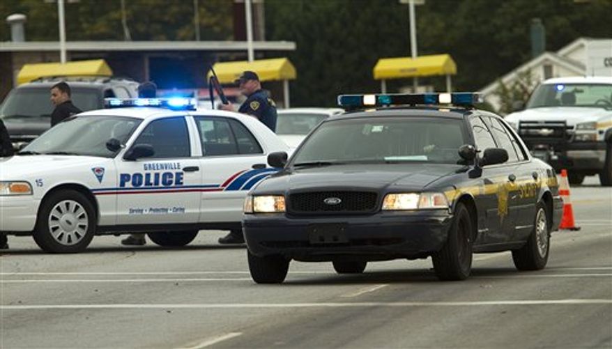 Greenville Police Officers close down a street near I-85 in Greenville, S.C. Friday, Oct. 28, 2011. A gunman fired on a South Carolina police officer checking on a suspicious license plate Friday, causing 10 schools in Greenville to go on lockdown. (AP Photo/Ken Osburn, The Greenville News)