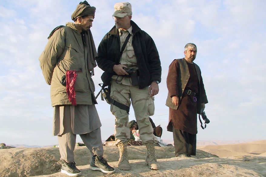 REMINDER: Now-retired Lt. Col. Max Bowers, Special Forces ground commander, advises Northern Alliance warlords in Afghanistan in November 2001. He was carrying with him a piece of the World Trade Center at the time. (Army Special Operations Command)