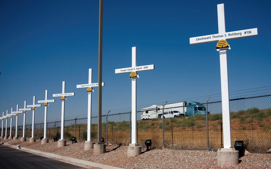 Steel crosses honoring Utah State Highway troopers killed in the line of duty line Interstate 15 in Hurricane, Utah. The Supreme Court on Monday declined to hear an appeal of a 10th Circuit Court ruling that the crosses on public property violate the Constitution. (Associated Press)
