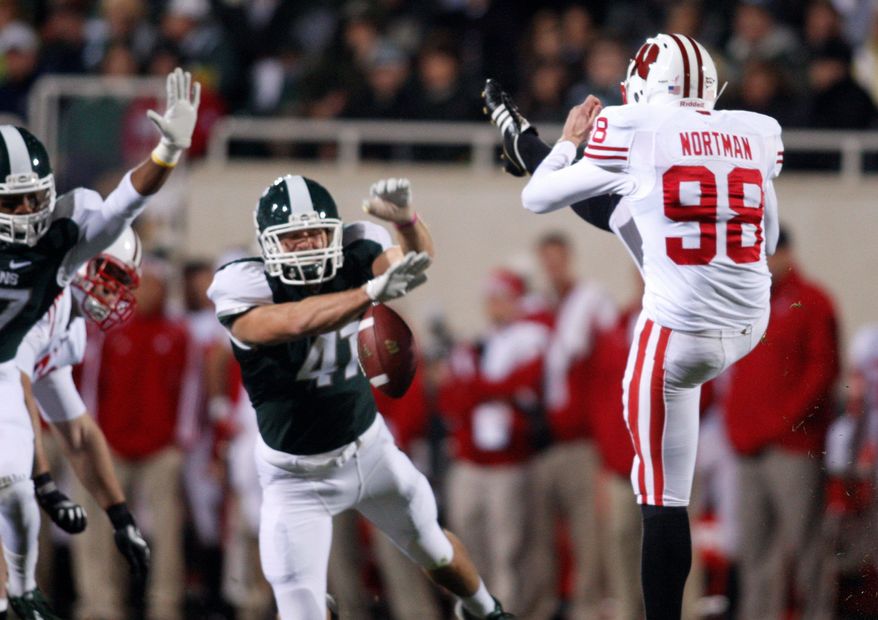 Michigan State's Kyler Elsworth (center) blocked a punt by Wisconsin's Brad Nortman, which was returned for a touchdown Oct. 22. The play proved pivotal in the Spartans' 37-31 victory. (Associated Press)