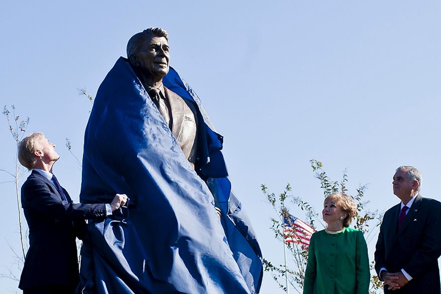 Frederick Ryan Jr. (left), chairman of the board of trustees of the Ronald Reagan Presidential Foundation, unveils a bronze statue of Ronald Reagan at Reagan National Airport in Arlington, Va., on Nov. 1, 2011. The statue was unveiled as part of a dedication ceremony on the centennial of the former president's birth. Also attending the event were former Transportation Secretary Elizabeth Dole (second from right) and Transportation Secretary Ray LaHood. (T.J. Kirkpatrick/The Washington Times)