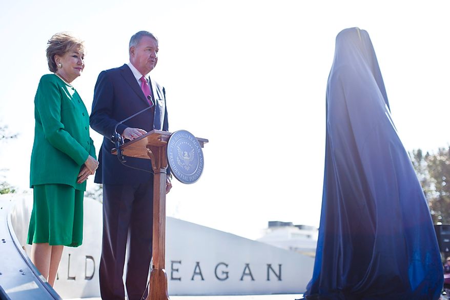 Former Transportation Secretary Elizabeth Dole (left) and Charles Snelling, chairman of the board of the Metropolitan Washington Airports Authority, speak at a dedication ceremony for a bronze statue of Ronald Reagan at Reagan National Airport in Arlington, Va., on Nov. 1, 2011. The statue was unveiled as part of a dedication ceremony on the centennial of the former president's birth. (T.J. Kirkpatrick/The Washington Times)