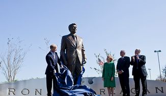 Frederick Ryan Jr. (left), chairman of the board of trustees of the Ronald Reagan Presidential Foundation, unveils a bronze statue of Ronald Reagan at Reagan National Airport in Arlington, Va., on Nov. 1, 2011. The statue was unveiled as part of a dedication ceremony on the centennial of the former president&#39;s birth. Also attending the event were former Transportation Secretary Elizabeth Dole (second from left); Charles Snelling (second from right), chairman of the board of the Metropolitan Washington Airports Authority; and Transportation Secretary Ray LaHood. (T.J. Kirkpatrick/The Washington Times)