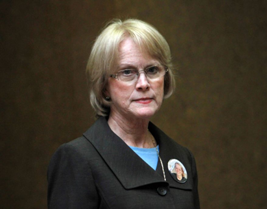 Phyllis Murray, wearing a photo of her slain daughter, waits to enter the trial of Brittany Norwood, who is accused of fatally bludgeoning Jayna Murray in March inside the Lululemon Athletica shop in Bethesda, Wednesday, Oct. 26, at Montgomery County Circuit Court in Rockville. Ms. Murray testified in the case on Tuesday. (AP Photo/Jacquelyn Martin)