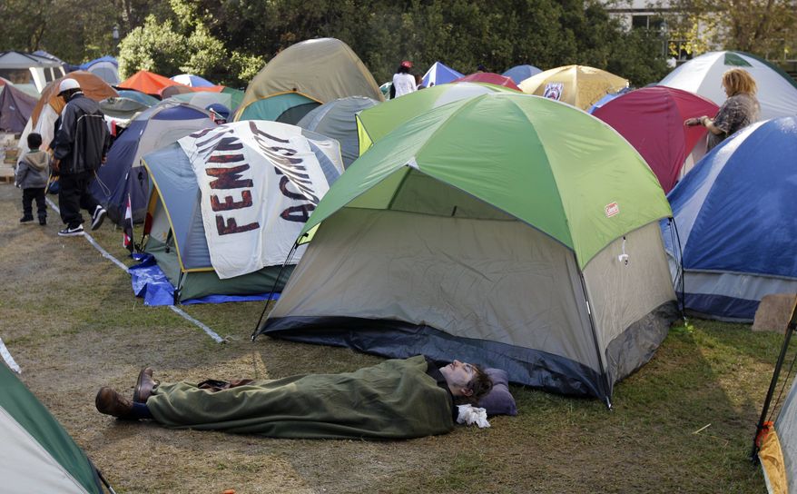 A protester sleeps under a blanket at the Occupy Oakland encampment Tuesday, Nov. 1, 2011, in Oakland, Calif. Oakland is bracing for Wednesday's citywide general strike, a hastily planned and ambitious action called by Occupy protesters a day after police forcibly removed their City Hall encampment last week. (AP Photo/Ben Margot)