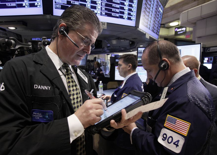 Daniel Kryger (left) works with fellow traders on the floor of the New York Stock Exchange on Wednesday, Nov. 2, 2011. (AP Photo/Richard Drew)