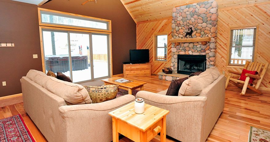 The great room has a floor-to-ceiling fireplace and a glass door that looks out onto the deck and oversized hot tub. All of the home's furnishings convey to the new owner.