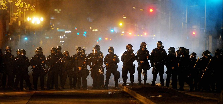 Riot police advance on Occupy Oakland protesters early Thursday in the port city. After a peaceful day-long protest by thousands of demonstrators, several hundred clashed with police trying to stop them from spraying graffiti, breaking windows and setting fire to garbage. (Associated Press)