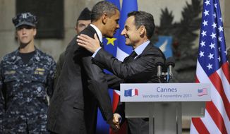 President Obama and French President Nicolas Sarkozy hug as they attend a French-U.S. alliance ceremony at the Cannes City Hall on Friday, Nov. 4, 2011, after the end of the second day of the G-20 summit. (AP Photo/Philippe Wojazer, Pool)