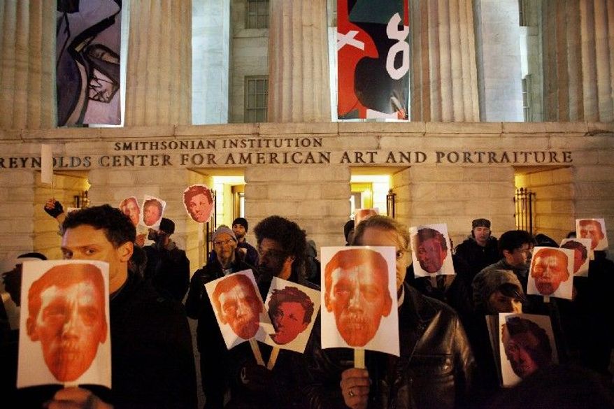 ** FILE ** In this Dec. 2, 2010, file photo, protesters hold masks in support of artist David Wojnarowicz on the steps of the Smithsonian's National Portrait Gallery, after a video by Wojnarowicz was removed from exhibition at the museum, in Washington. The Andy Warhol Foundation said Monday, Dec. 13, 2010, it will withhold future funding to the Smithsonian Institution unless a video removed from the gallery after a Catholic group complained is restored.(AP Photo/Jacquelyn Martin, File)
