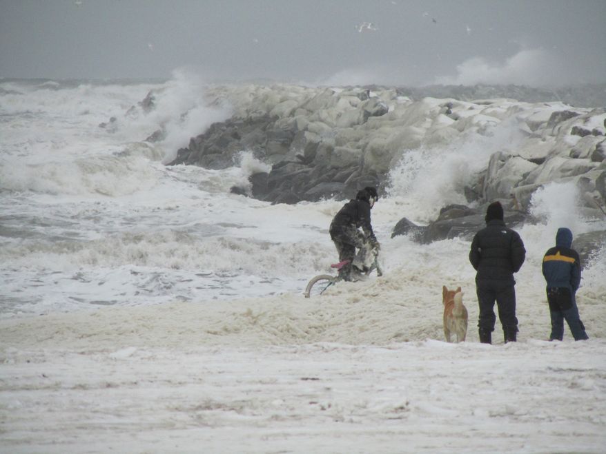 Kids in Nome, Alaska, play in sea foam near the town's harbor late on Tuesday, Nov. 8, 2011, as a big Bering Sea storm starts kicking up waves. (AP Photo/Peggy Fagerstrom)