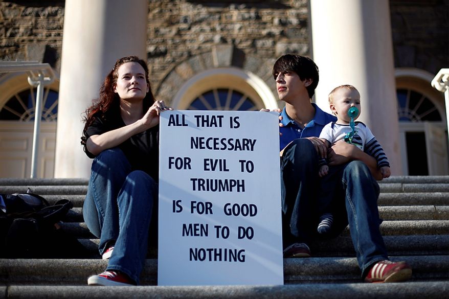 Lauren Acquaviva (left), accompanied by her husband, Michael, and son, 10-month-old Matthias, protest outside an administrative building on the Penn State campus on Tuesday, Nov. 8, 2011, in State College, Pa. The family was protesting the university administration's handling of an alleged child-sex-abuse scandal involving a former assistant coach. (AP Photo/Matt Rourke)