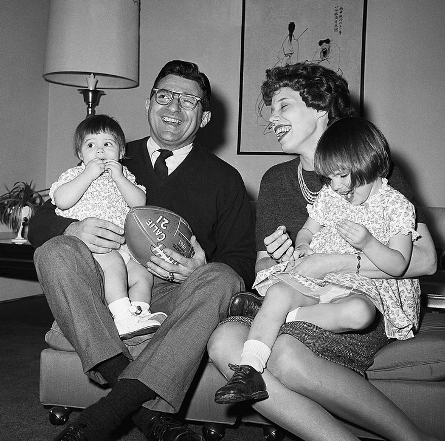 In this Feb. 16, 1966 file photo, new Penn State head football coach Joe Paterno poses with his one-year-old daughter Mary Kathryn on his lap and his wife Suzanne, with two-year-old daughter Diana Lynne, at their home in University Park, Pa. Paterno say he plans to retire at the end of the season, his long and illustrious career brought down because he failed to do all he could about an allegation of child sex abuse against a former assistant. (AP Photo/Paul Vathis, File)