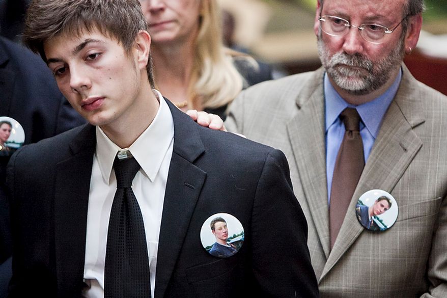 Jimmy Hoover, 19, left, younger brother of John Hoover, a victim killed in crash by Kevin Coffay, is comforted by a family member while listening as John McCarthy, Montgomery County state's attorney, speaks to the press after Coffay, 20, pled guilty in Montgomery County Circuit Court on three counts of vehicular manslaughter and one count of leaving the scene of a fatal crash, in Rockville, Md. on Nov. 10, 2011. Hoover wears a pin with a photograph of his brother.
(T.J. Kirkpatrick/ The Washington Times)