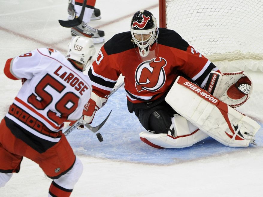 New Jersey Devils goaltender Martin Brodeur, right, makes a save on a shot by Carolina Hurricanes' Chad LaRose during the second period of an NHL hockey game Tuesday, Nov. 8, 2011, in Newark, N.J. (AP Photo/Bill Kostroun)