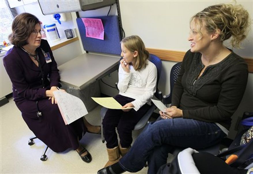 In this Tuesday, Nov. 1, 2011 photo, Dr. Elaine Urbina, left, goes over test results with Joscelyn Benninghoff, center, 10, and her mother, Elizabeth Duruz, at Children's Hospital in Cincinnati. Benninghoff is taking medication to control her cholesterol. In new guidelines released Friday, Nov. 11, 2011, doctors are recommending that every child be tested for high cholesterol by around age 10 to prevent heart disease later in life. (AP Photo/Al Behrman)