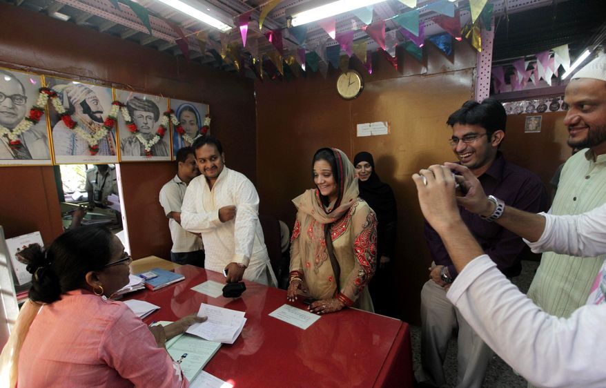 Mohammed Zaffar Patel, standing second left, weds Jannat Khan, third left, at a marriage registrar's office in Mumbai, India, Friday, Nov. 11, 2011. Because of the days numerical conjunction, 11.11.11, people believe it to be an auspicious day leading thousands of couples to tie their knots on this day across India. (AP Photo/Rajanish Kakade)