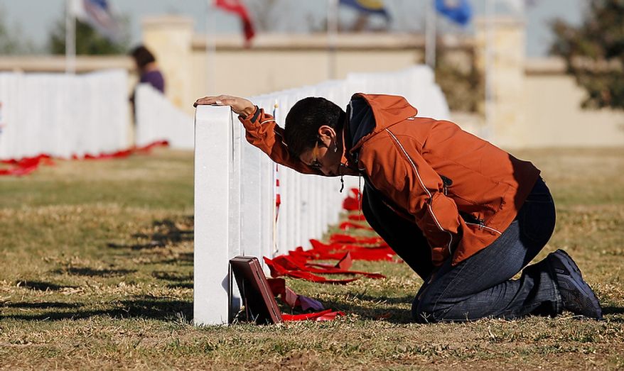 Juanita Moreno visits the grave site of her brother during a Veteran's Day observance at Fort Sam Houston National Cemetery, Friday, Nov. 11, 2011, in San Antonio. (AP Photo/Eric Gay)
