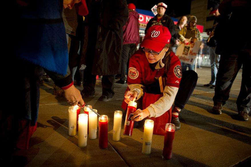 Michi Szpatura of Arlington, Va, lights candles for other to hold during a candlelight vigil for Nationals' rookie catcher Wilson Ramos at Nationals Park in Washington, DC, Friday, November 11, 2011. Ramos was kidnapped by armed gunmen in front of his family home in Venezuela on Wednesday night. (Rod Lamkey Jr. / The Washington Times)