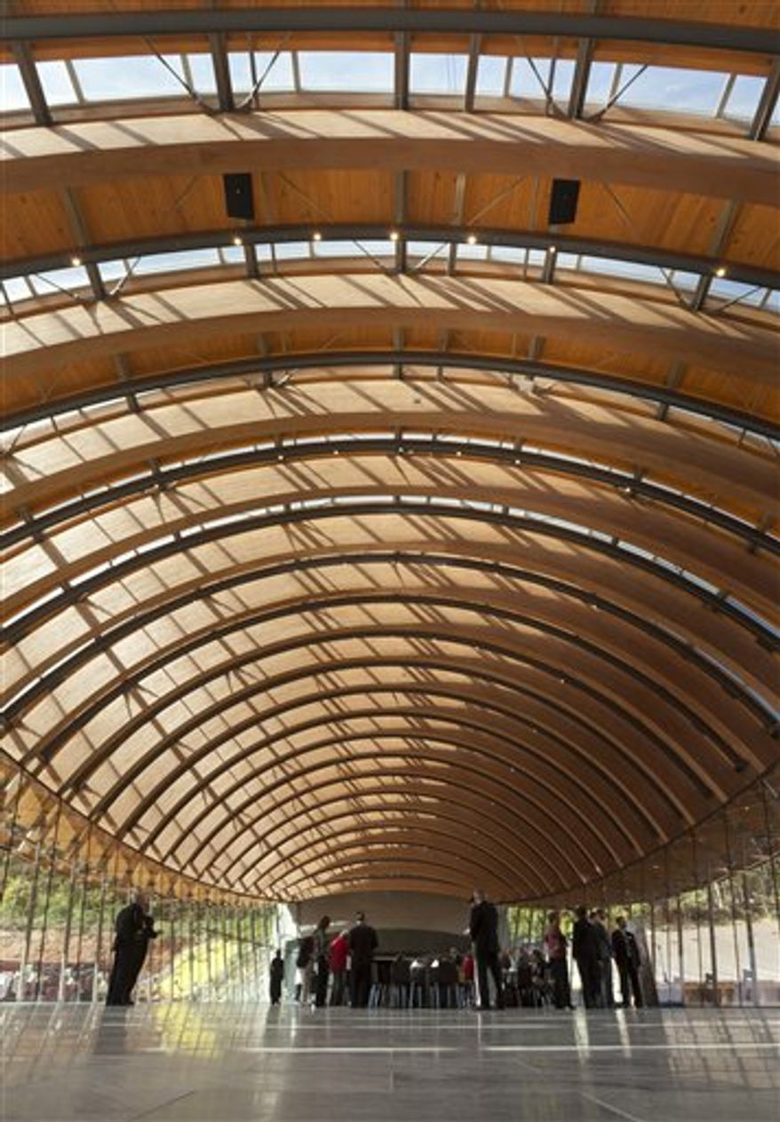 In this photo taken Oct. 13, 2011, guests attending a preview of Crystal Bridges Museum of American Art stand beneath curved wooden beams and skylights in Eleven Restaurant at the museum in Bentonville, Ark. The Crystal Bridges Museum of American Art was created using pieces acquired by Wal-Mart heir Alice Walton, who wanted to build something important in her hometown of Bentonville. The Moshe Safdie-designed museum is scheduled to open Nov. 11. (AP Photo/Danny Johnston)