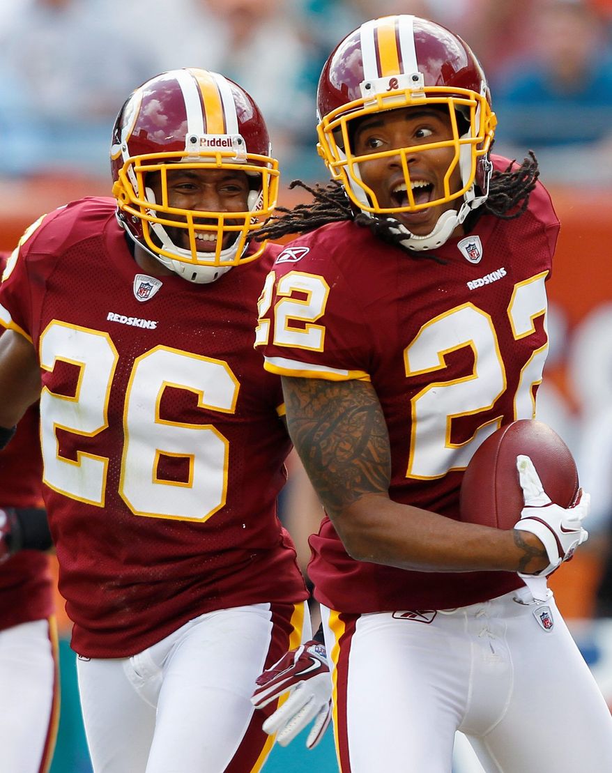 Redskins cornerback Kevin Barnes celebrates with Josh Wilson during the first quarter after intercepting a pass from Dolphins quarterback Matt Moore. The play was set up thanks to pressure by nose tackle Barry Cofield. (Associated Press)